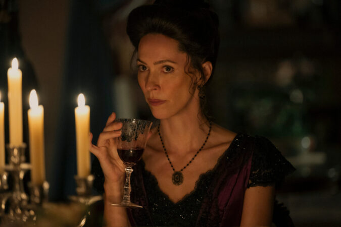 Un coup de hache dans le catalogue Netflix : Lizzie Borden est la nouvelle Monster 4 "Woman in period costume sits at a candlelit table, holding a glass of red wine, with a serious expression in a dimly lit, elegant room."